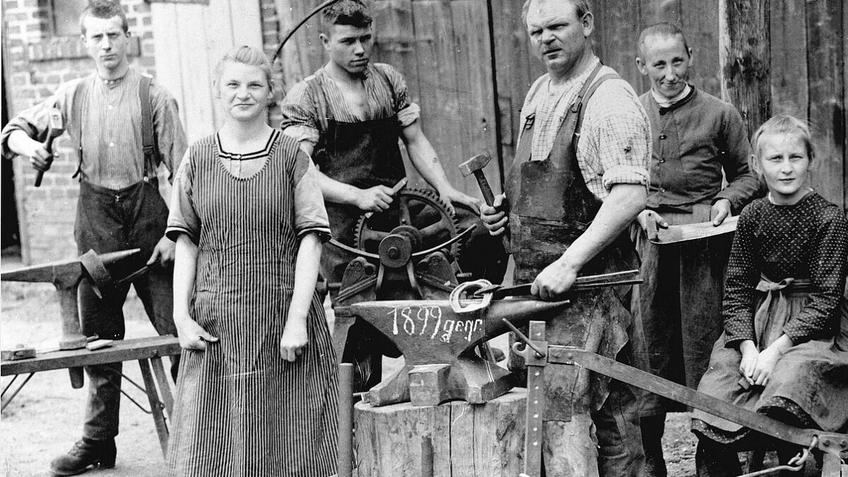 Hier zu sehen ist die Schmiede von Karl Debus in Wallau aus der Zeit um 1930. Familienangehörige und Mitarbeiter präsentieren dem Fotografen ihre Arbeitsgeräte. (Foto: Hinterlandmuseum Schloss Biedenkopf, Sammlung Erwin Schneider)